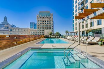 Heated outdoor pool and spa surrounded by luxe loungers, gourmet bbq grills, and ambient fire features